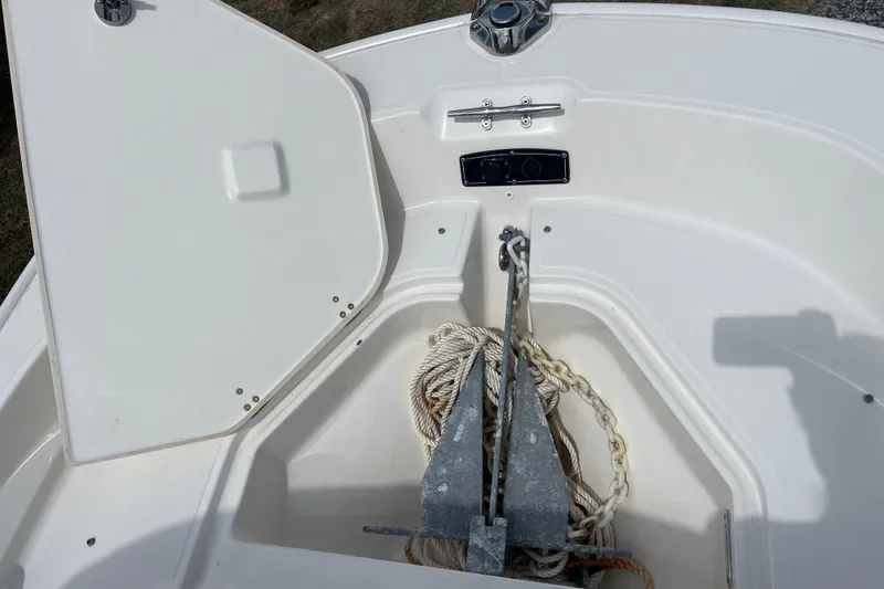 Slide: The Image of 2021 Boston Whaler 150 Montauk anchor storage with open hatch and rope. - 8