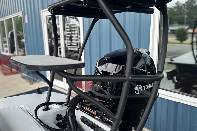 Slide: The Image of 2026 Chittum Skiffs 18 Challenger 2.0 with Tohatsu engine, docked near blue building. - 6