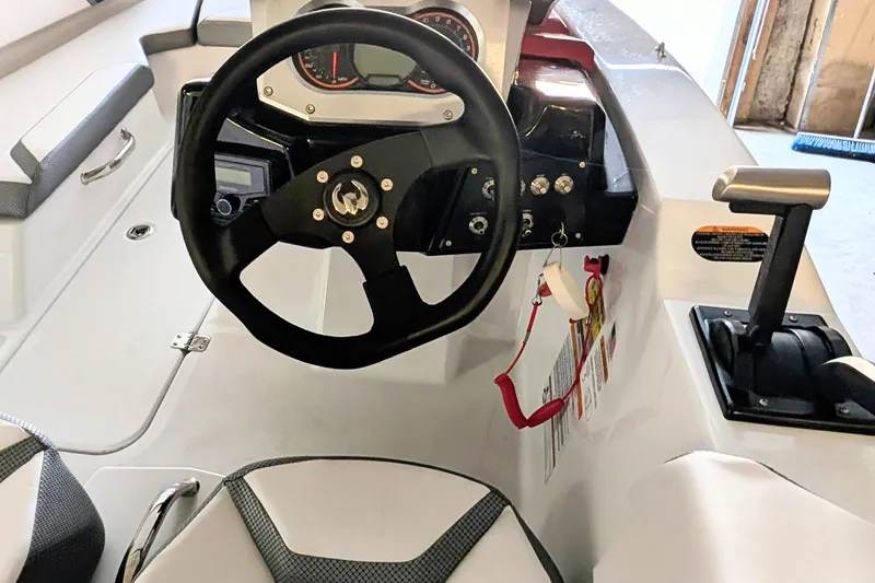 Slide: The Image of 2023 Scarab 165 ID boat cockpit with steering wheel and controls. - 4