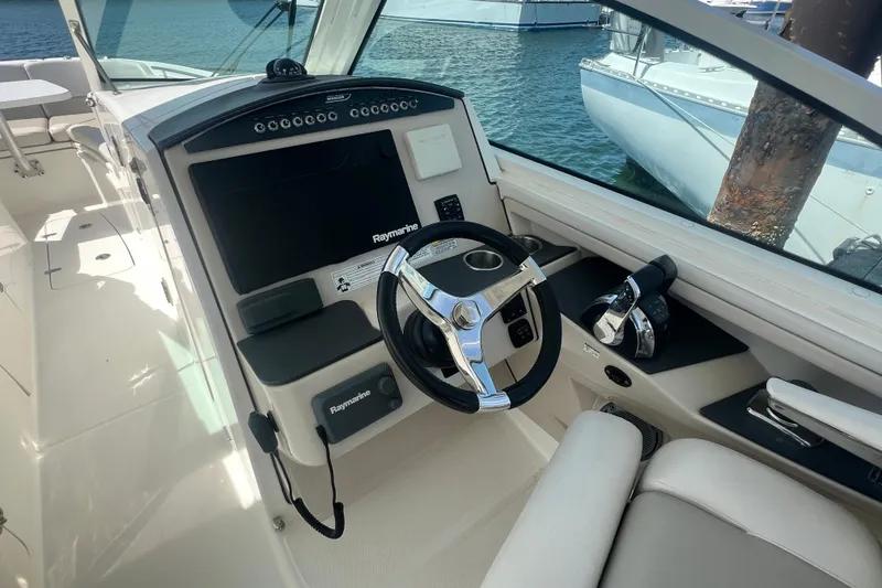 Slide: The Image of Cockpit of 2015 Boston Whaler 320 Vantage with steering wheel and Raymarine electronics. - 13