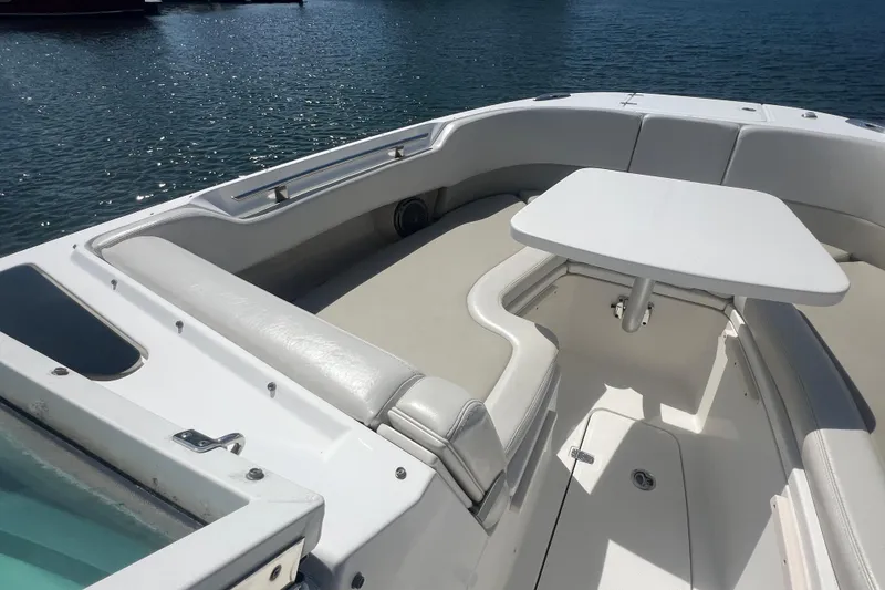 Slide: The Image of 2015 Boston Whaler 320 Vantage boat interior with seating and table on water. - 14