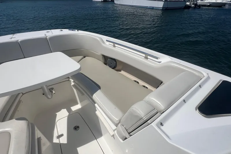 Slide: The Image of 2015 Boston Whaler 320 Vantage boat interior with seating and table on calm water. - 15