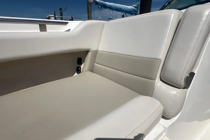 Slide: The Image of 2015 Boston Whaler 320 Vantage boat seating area with white and beige upholstery. - 17