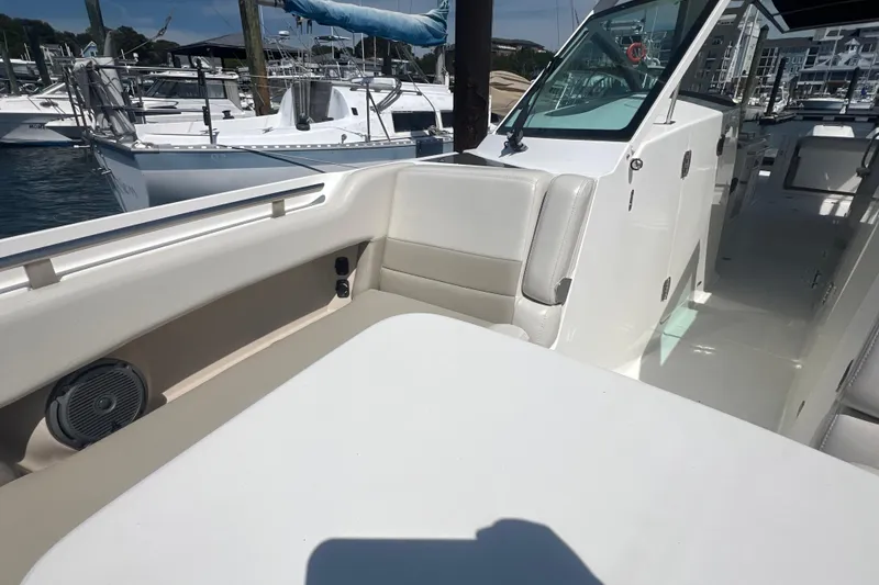 Slide: The Image of 2015 Boston Whaler 320 Vantage boat interior at marina, showcasing seating and deck area. - 19