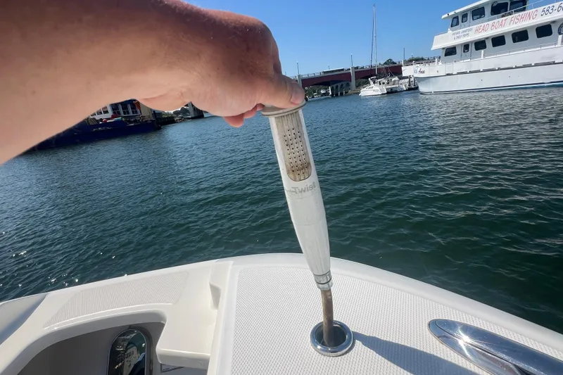 Slide: The Image of Hand holding a boat shower nozzle on a 2015 Boston Whaler 320 Vantage. - 24