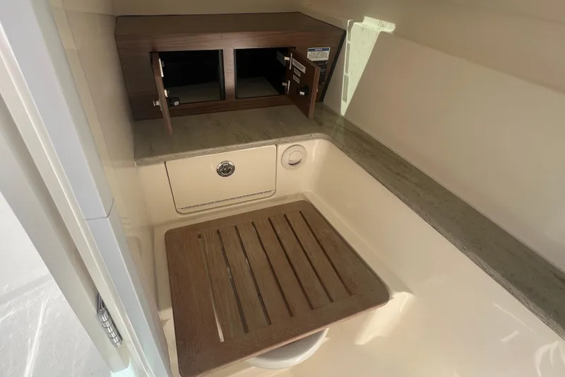 Slide: The Image of Interior of 2015 Boston Whaler 320 Vantage boat, featuring a compact storage area. - 25