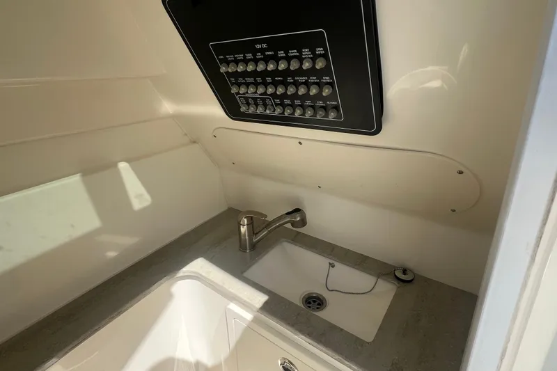 Slide: The Image of Interior of a 2015 Boston Whaler 320 Vantage, featuring a sink and control panel. - 26