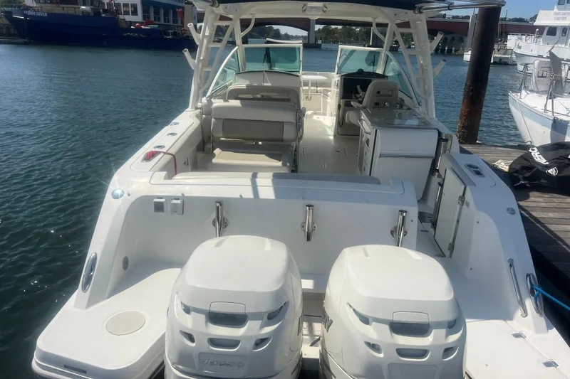 Slide: The Image of 2015 Boston Whaler 320 Vantage boat docked, showcasing spacious deck and dual engines. - 3