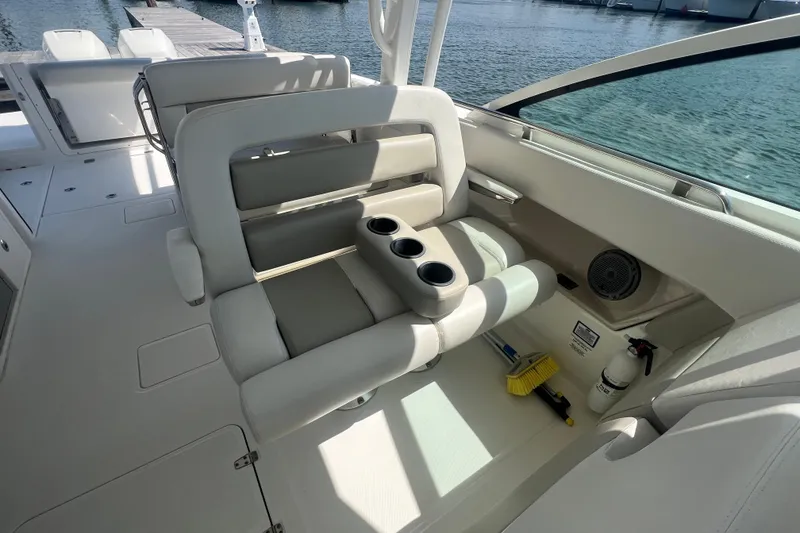 Slide: The Image of 2015 Boston Whaler 320 Vantage boat interior with cushioned seating and cup holders. - 33