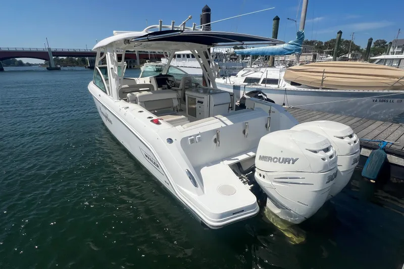 Slide: The Image of 2015 Boston Whaler 320 Vantage boat docked, featuring dual Mercury engines. - 4