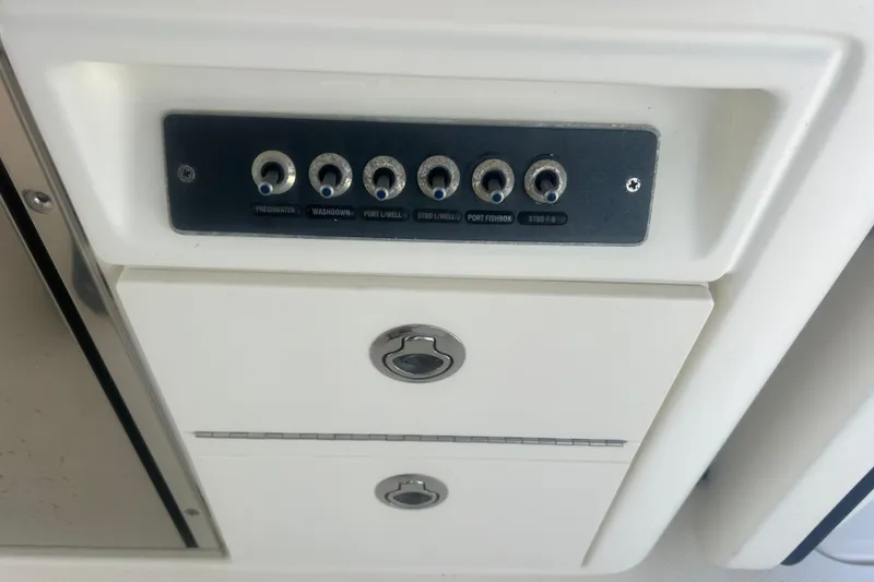 Slide: The Image of Control panel on a 2015 Boston Whaler 320 Vantage boat, featuring multiple switches. - 43