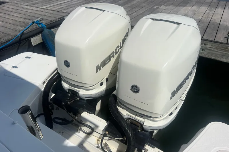 Slide: The Image of Twin Mercury outboard engines on a 2015 Boston Whaler 320 Vantage boat at dock. - 47