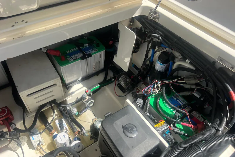 Slide: The Image of Engine compartment of a 2015 Boston Whaler 320 Vantage with visible wiring and battery. - 50
