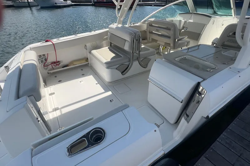 Slide: The Image of 2015 Boston Whaler 320 Vantage boat interior with seating and storage, docked by the water. - 7