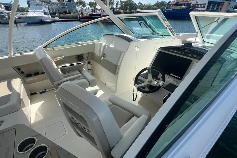 Slide: The Image of 2015 Boston Whaler 320 Vantage boat interior with helm, seating, and water view. - 8