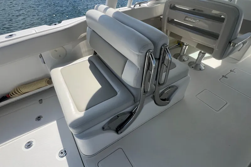 Slide: The Image of 2015 Boston Whaler 320 Vantage boat interior with cushioned seating and chrome accents. - 9