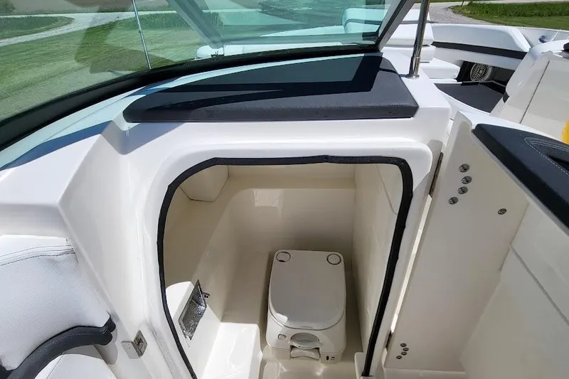 Slide: The Image of 2016 Sea Ray SLX 250 boat interior with compact marine toilet. - 9