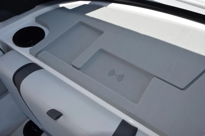 Slide: The Image of 2026 Yamaha Boats AR220 interior with wireless charging pad and cup holder. - 19