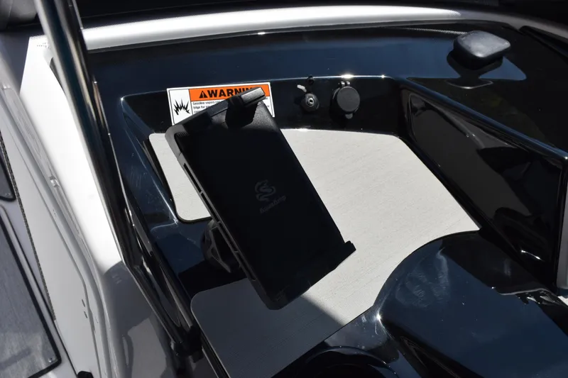 Slide: The Image of Interior view of 2026 Yamaha Boats AR220, featuring dashboard details and warning label. - 20