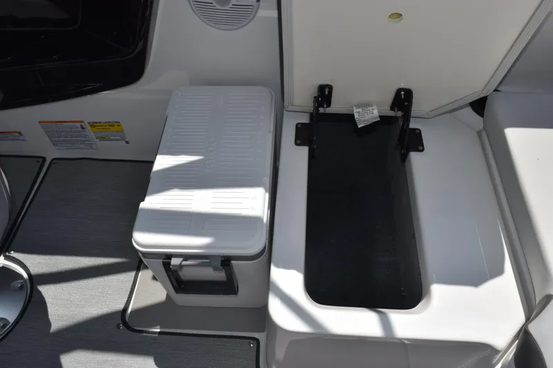 Slide: The Image of 2026 Yamaha Boats AR220 interior storage compartment with cooler and seating area. - 22