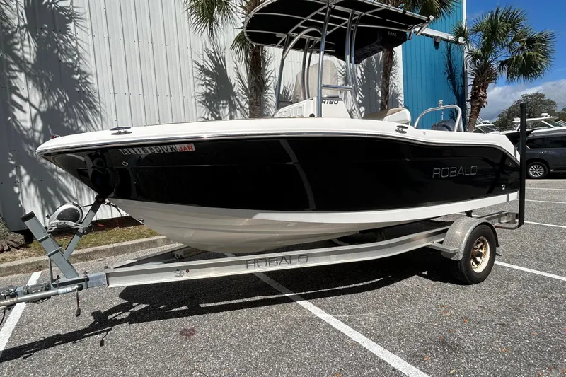 The Image of 2018 Robalo R180 Center Console boat on trailer, parked outdoors. - 1