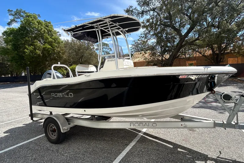 Slide: The Image of 2018 Robalo R180 Center Console boat on trailer in sunny parking lot. - 6
