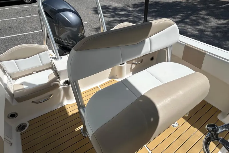 Slide: The Image of 2018 Robalo R180 Center Console boat interior with cushioned seating and wood-style flooring. - 8