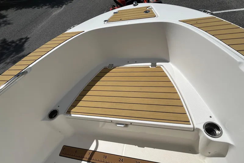 Slide: The Image of 2018 Robalo R180 Center Console boat with teak-style deck and storage compartments. - 9
