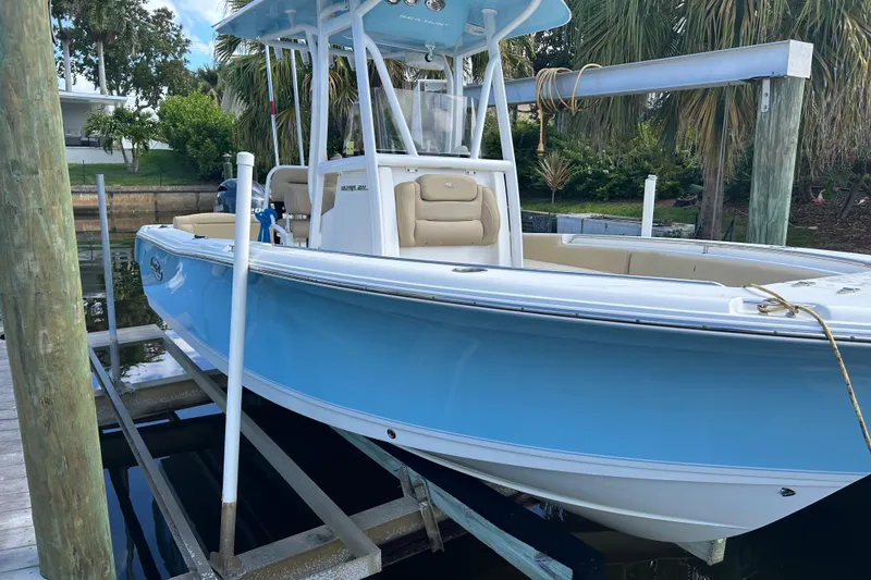 The Image of 2016 Sea Hunt Ultra 211 boat on trailer, displayed outdoors with sale signage. - 0