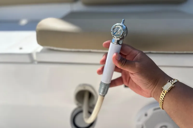 Slide: The Image of Hand holding a showerhead on a 2016 Sea Hunt Ultra 211 boat. - 100