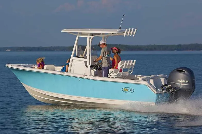 Slide: The Image of 2016 Sea Hunt Ultra 211 boat with SH logo, blue hull, parked outdoors. - 19
