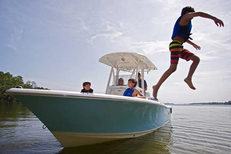 Slide: The Image of 2016 Sea Hunt Ultra 211 boat on trailer at dealership under clear blue sky. - 20