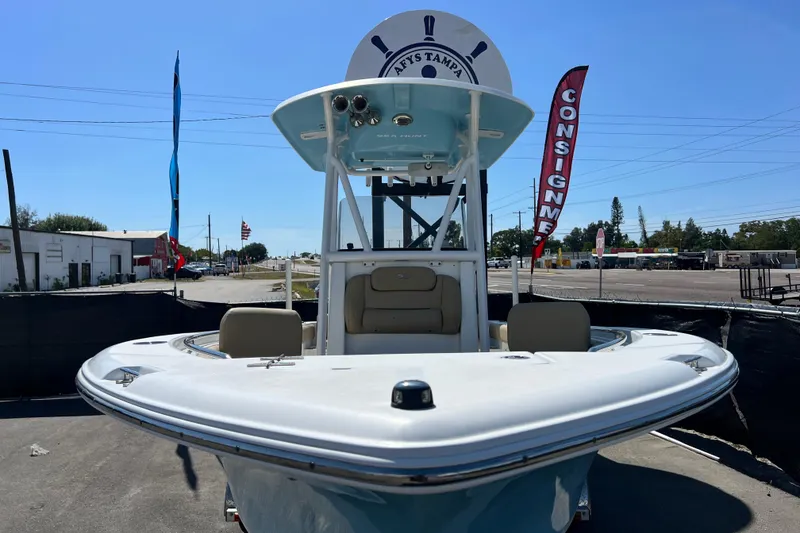 Slide: The Image of 2016 Sea Hunt Ultra 211 boat displayed outdoors with consignment banners. - 27