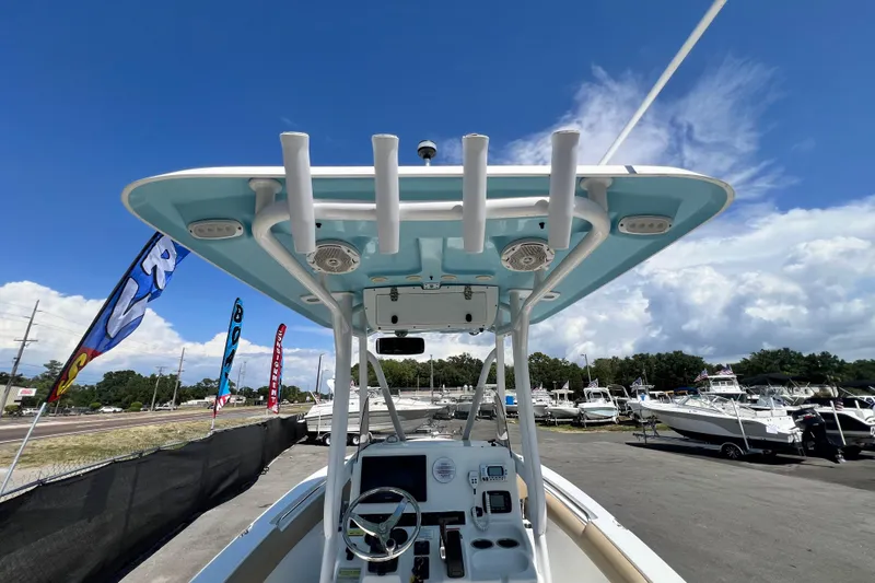 Slide: The Image of 2016 Sea Hunt Ultra 211 boat with T-top and console, displayed at a marina under a clear sky. - 31
