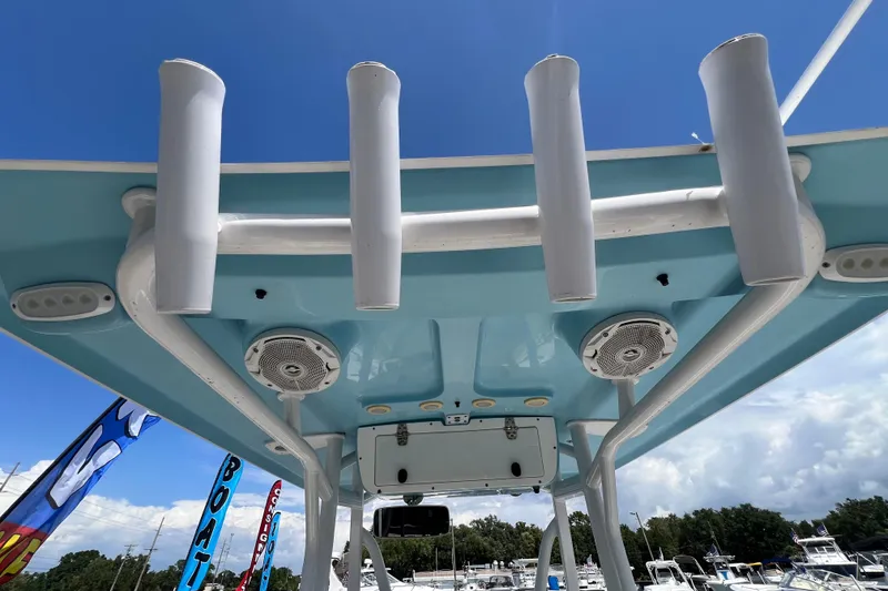 Slide: The Image of 2016 Sea Hunt Ultra 211 boat roof with rod holders and speakers under blue sky. - 32