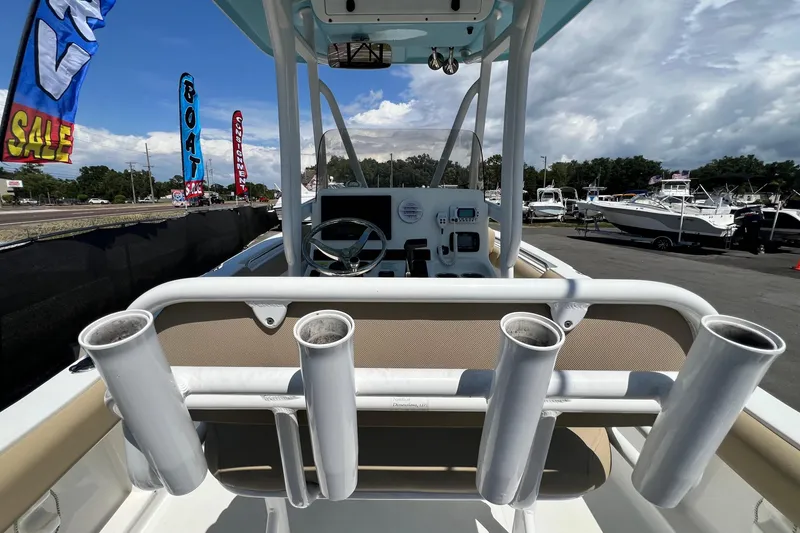 Slide: The Image of 2016 Sea Hunt Ultra 211 boat interior with rod holders, steering wheel, and sale banners. - 34