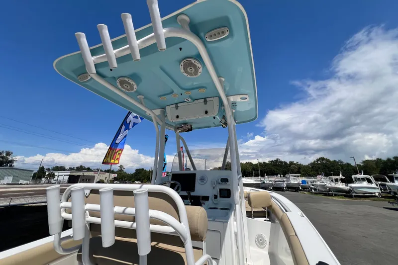 Slide: The Image of 2016 Sea Hunt Ultra 211 boat with T-top, rod holders, and clear sky background. - 40