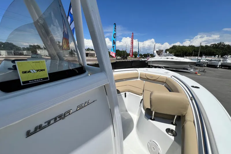Slide: The Image of 2016 Sea Hunt Ultra 211 boat with tan seating, displayed at a marina under a clear blue sky. - 42