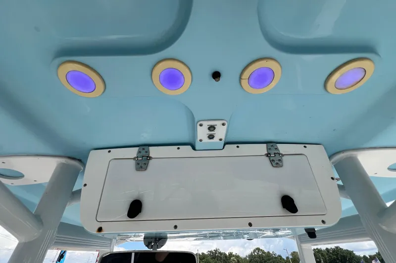 Slide: The Image of 2016 Sea Hunt Ultra 211 boat interior with blue lights and storage compartment. - 45