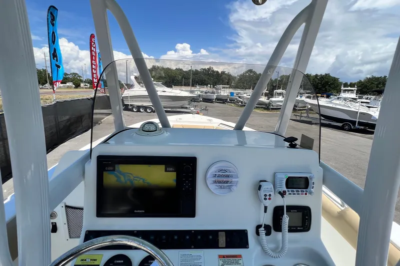 Slide: The Image of 2016 Sea Hunt Ultra 211 boat dashboard with navigation equipment and marina view. - 48