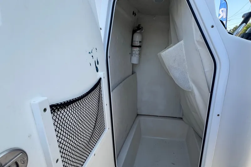 Slide: The Image of Interior of a 2016 Sea Hunt Ultra 211 boat, featuring storage and safety equipment. - 51