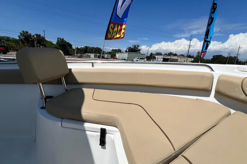 Slide: The Image of 2016 Sea Hunt Ultra 211 boat interior with beige seating, sale flags visible. - 60