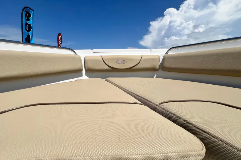 Slide: The Image of 2016 Sea Hunt Ultra 211 boat interior with beige seating under a clear blue sky. - 65
