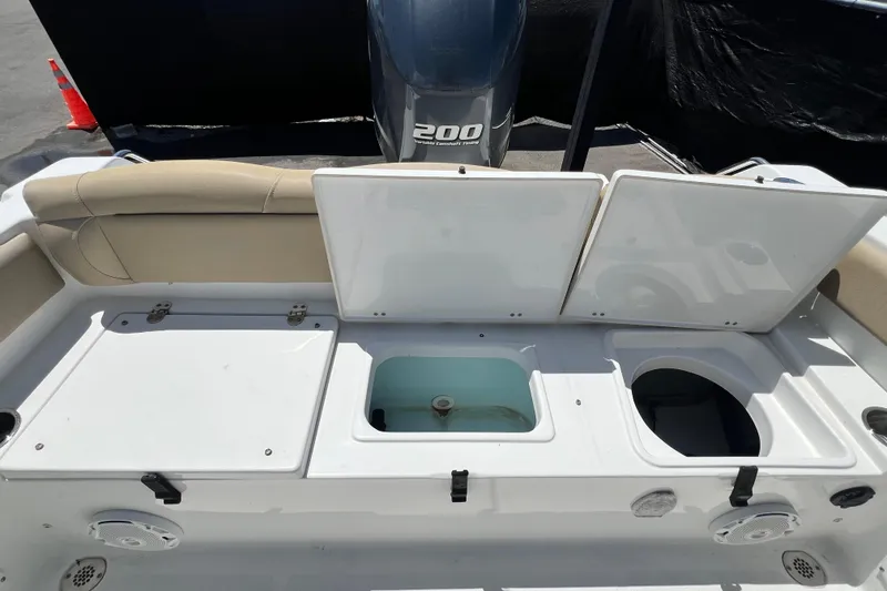 Slide: The Image of 2016 Sea Hunt Ultra 211 boat interior with storage compartments and Yamaha 200 engine. - 76