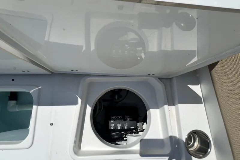 Slide: The Image of 2016 Sea Hunt Ultra 211 boat compartment with NOCO Genius charger visible. - 80