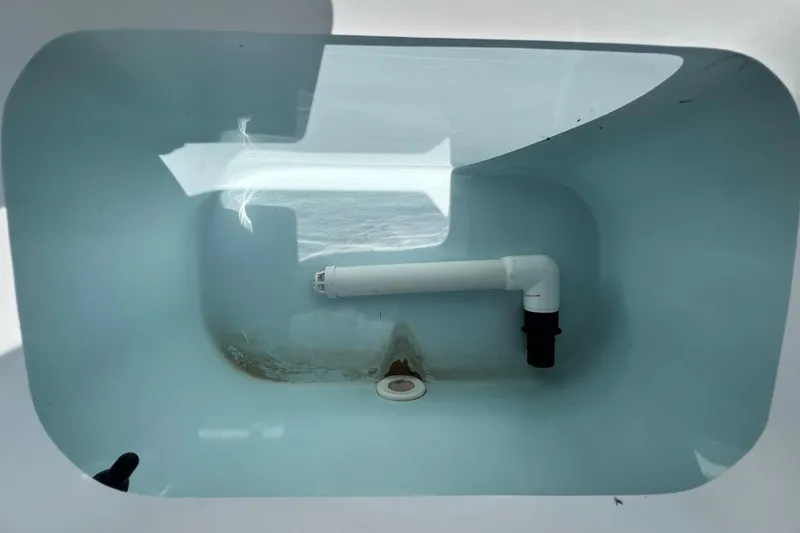 Slide: The Image of Livewell interior of 2016 Sea Hunt Ultra 211 boat, featuring plumbing and drain. - 81