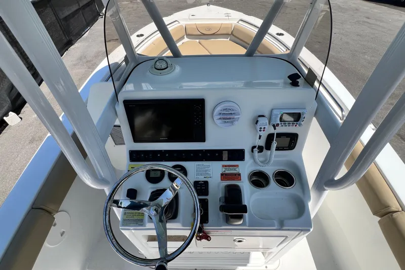 Slide: The Image of 2016 Sea Hunt Ultra 211 boat console with steering wheel, navigation, and communication equipment. - 86