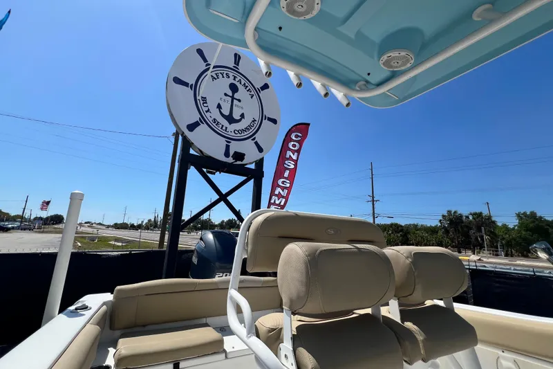 Slide: The Image of 2016 Sea Hunt Ultra 211 boat at dealership with signage and clear blue sky. - 89