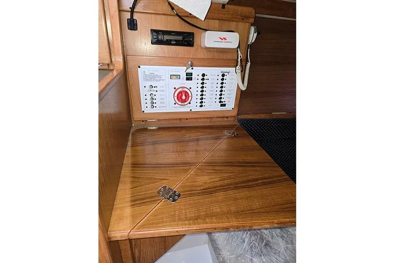 Slide: The Image of Control panel inside a 2005 Catalina 310 sailboat with wooden cabinetry. - 14