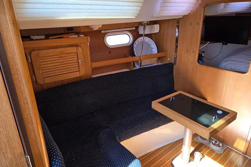 Slide: The Image of Interior of a 2005 Catalina 310 sailboat with cozy seating and wooden accents. - 7